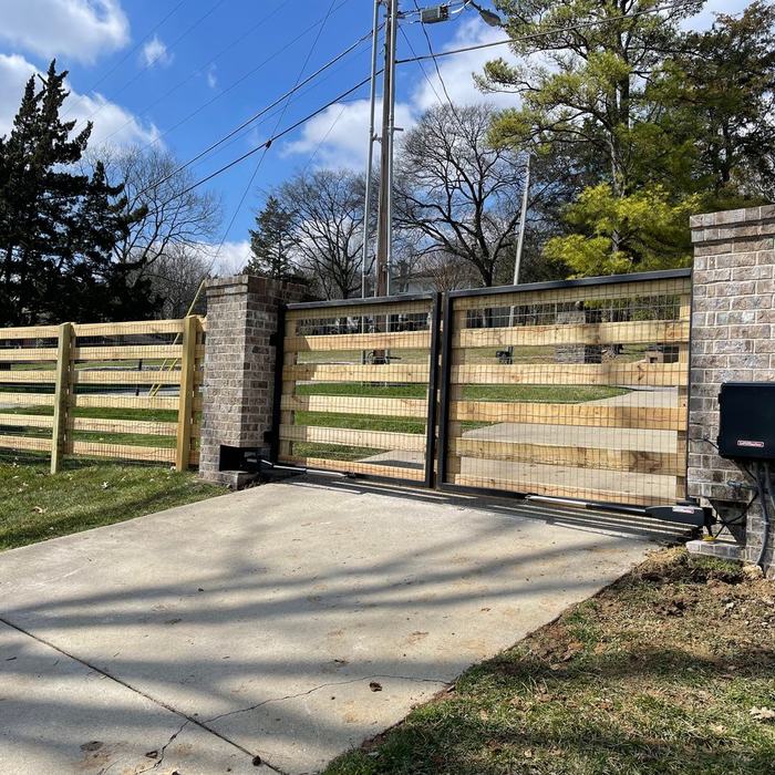 Horizontal board driveway gate set between brick columns at a home entrance