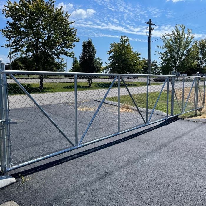 Double swing chain link gate across a commercial driveway