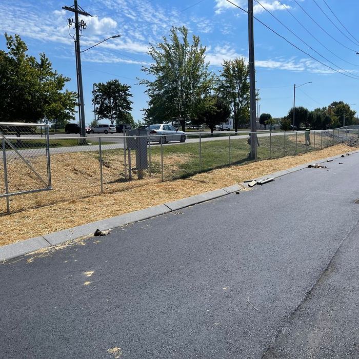 Chain link gate and fence line along the road frontage of a commercial lot