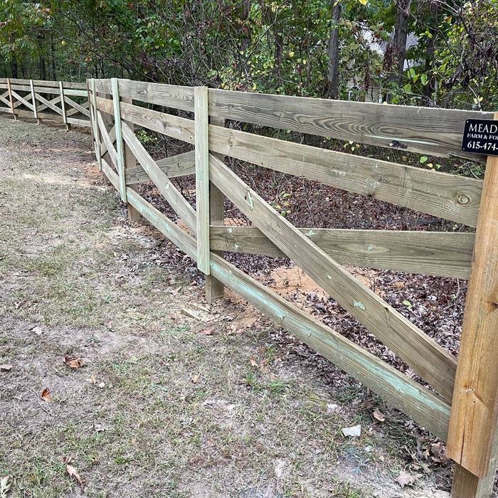 Rail fence with cross bracing built down a steep gravel bank