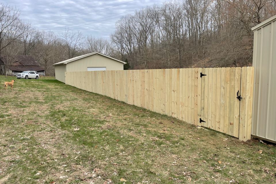 Six foot wooden privacy fence enclosing a backyard